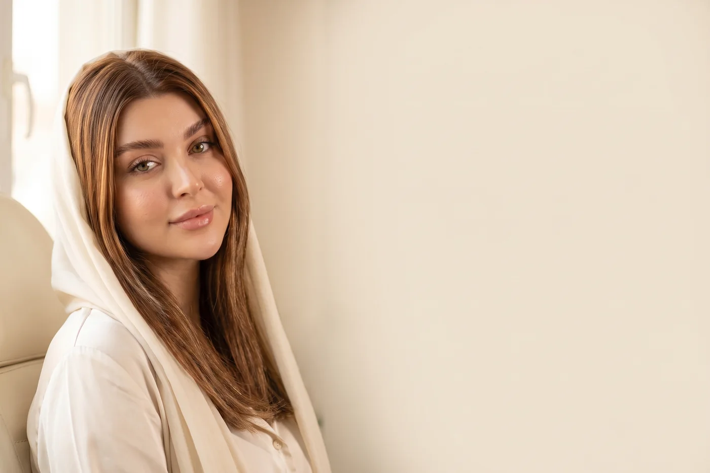 زنی حدود سی‌وپنج ساله کنار پنجره‌ای روشن، با حالتی آرام